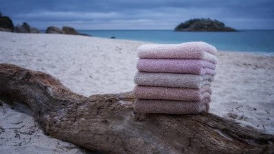 Abyss Super Pile: A Heavy Weight Towel With Spa-Like Luxury and Superior Performance Pile Folded Towels On Log Sandy Beach Ocean 