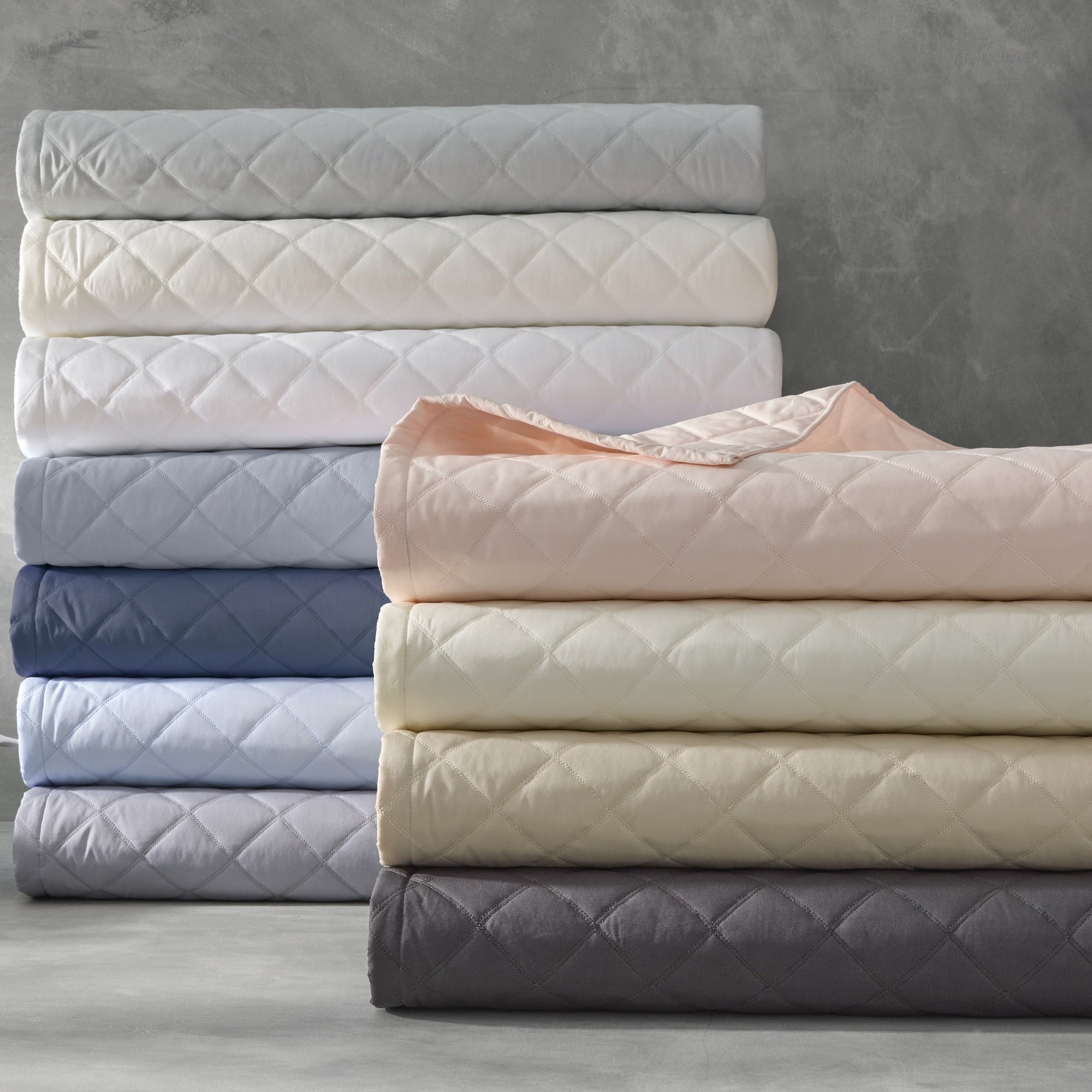 Stack of Matouk Milano Quilt Bedding in Different Colors