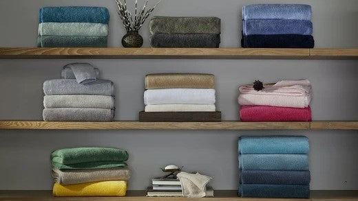 A Guide to Buying Luxury Bath Towels: Fabric, GSM, and More Folded Piled Shelves Fine Linens