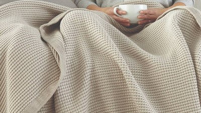 COMFORT AND JOY: SIX GREAT THROWS TO GIVE AND GET THIS SEASON Cup of Coffee Blanket Fine Linens on Couch