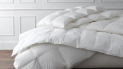 A Buyer’s Guide to Down and Down-Alternative Comforters Fine Linens on Bed in Bedroom