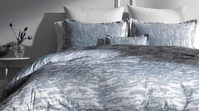 Five Timeless Textiles That Never Go Out of Style Printed Bedding Pillows on Bed