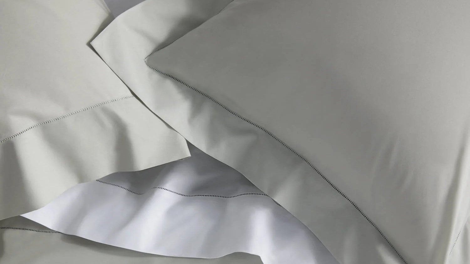 Learn about the difference between Percale and Sateen sheets and bedding Fine Linens Pillows Layered Top View