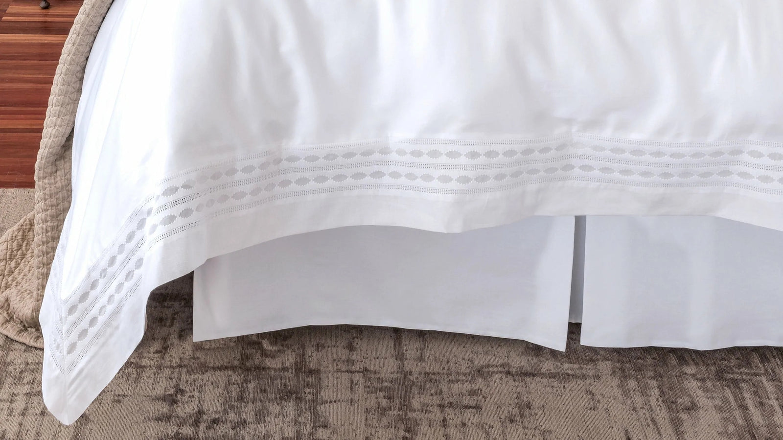 White bed skirt and box spring covering bed end