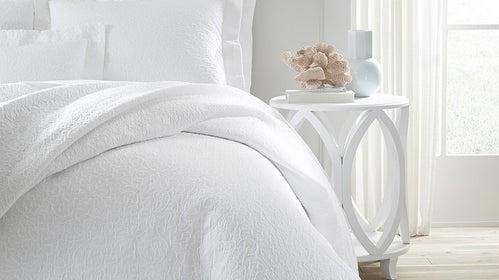 Understanding Bed Topper Options: Coverlets, Quilts, and Duvet Covers Fine Linens on Bed Nightstand