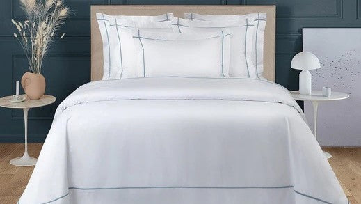 Buyer’s Guide to Yves Delorme Bed Linen: Comparing Triomphe, Athena and Lutece Bedding Collections Fine Linens on Bed Flowers Nightstand