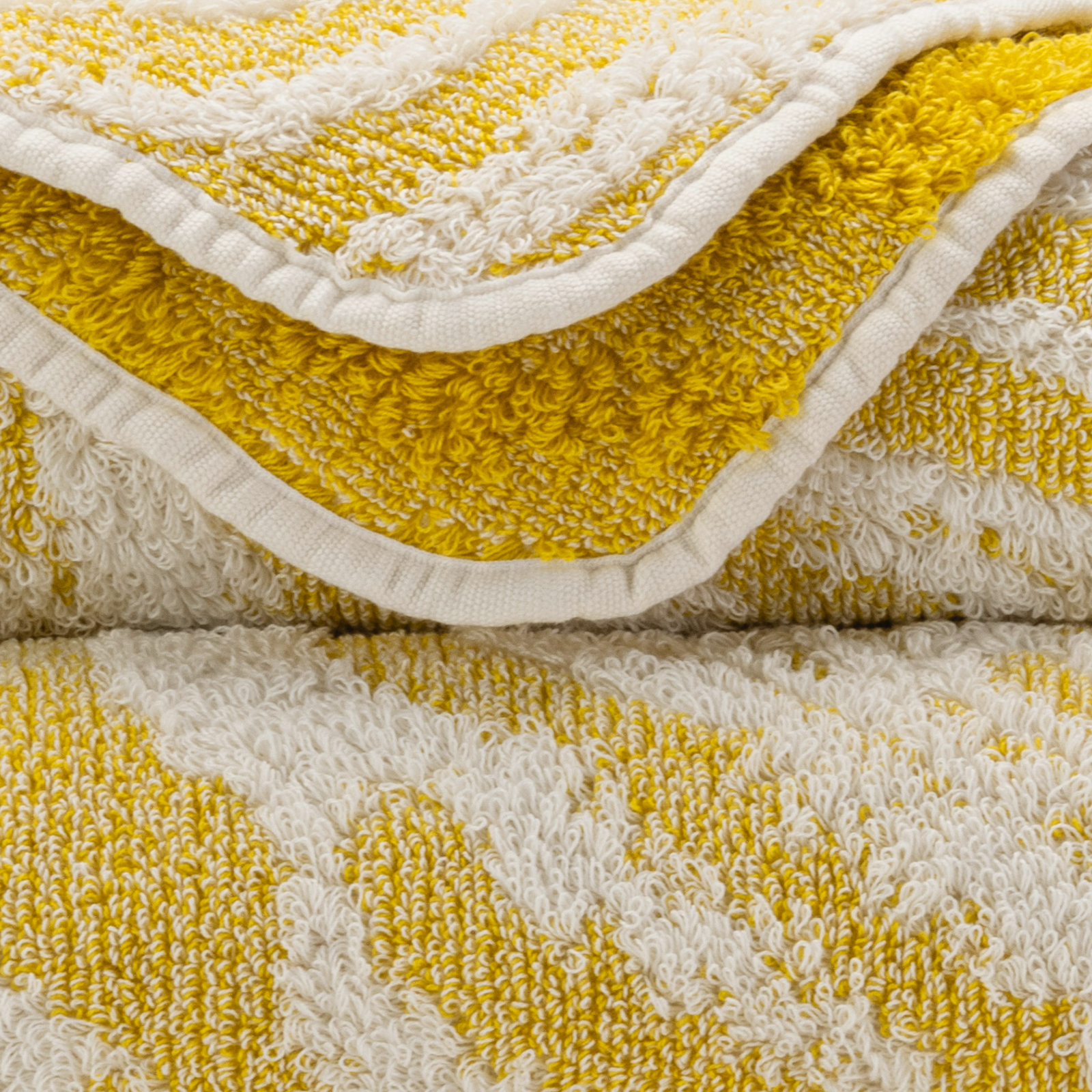 Tilted Stack of Abyss Fogo Bath Towels in Yuzu Color