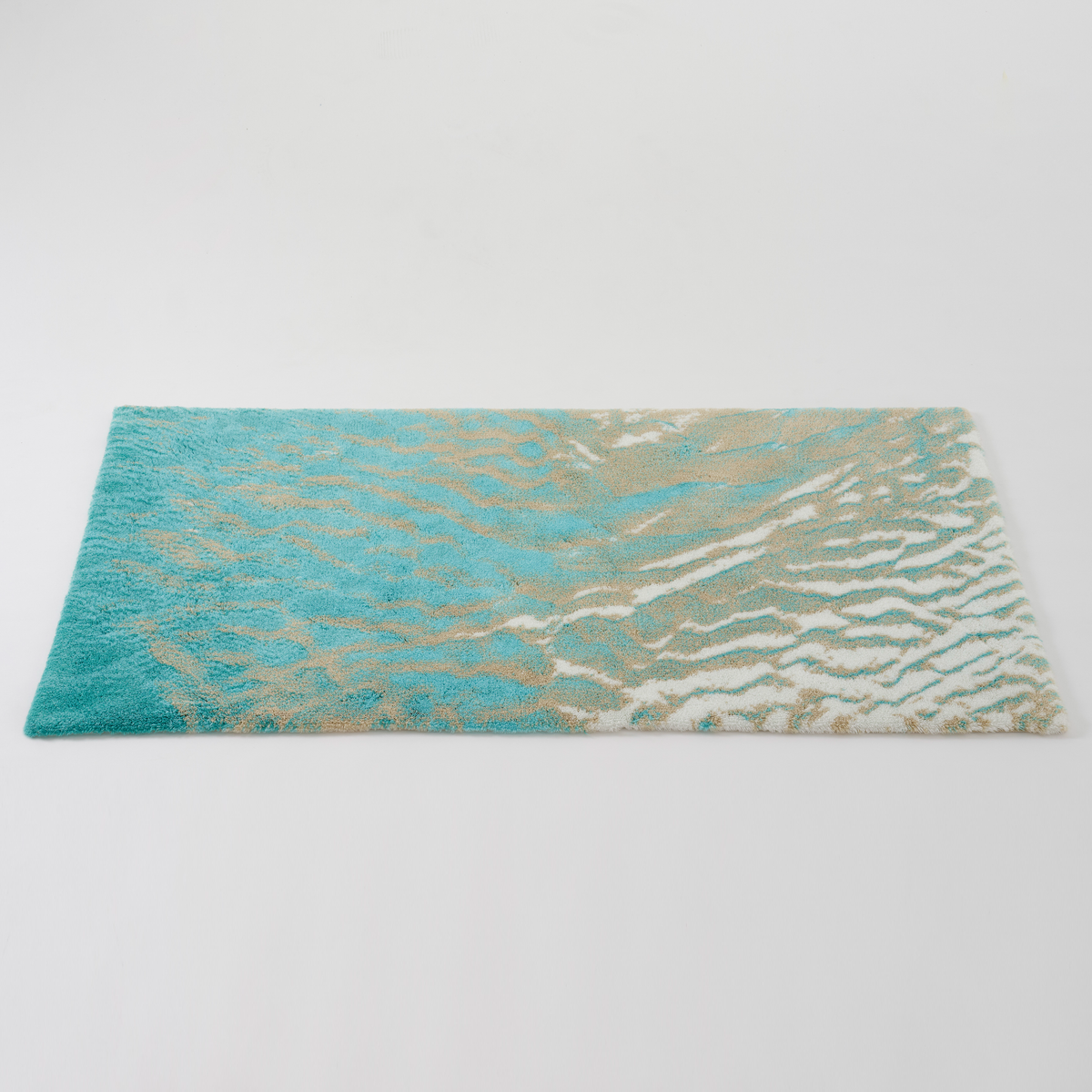Angled view of Turquoise colored Abyss Habidecor Beach Bath Rug