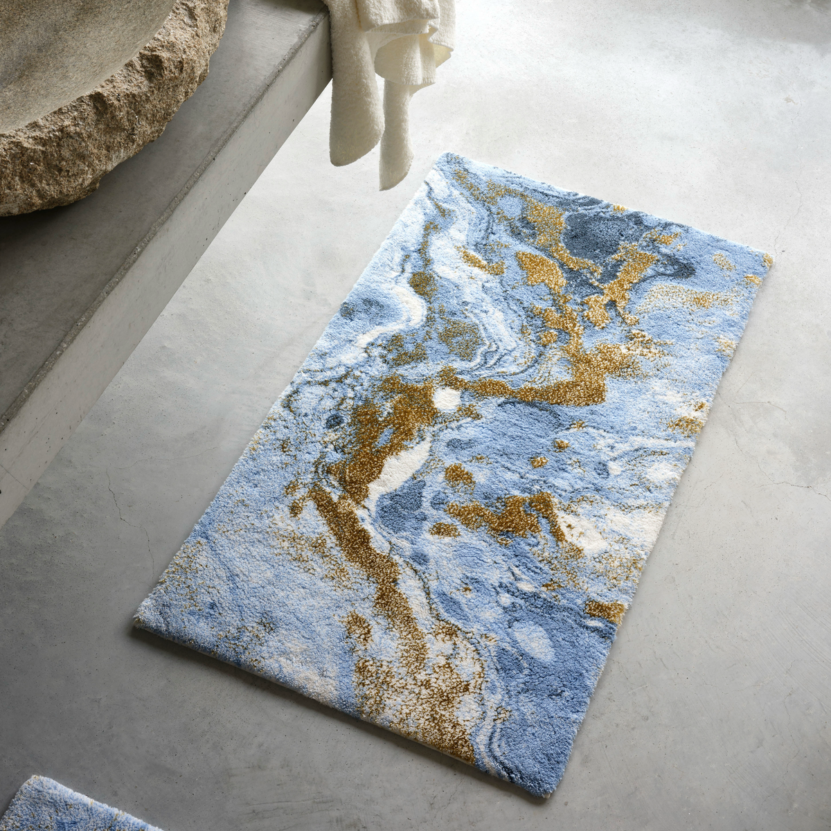 Powder Blue colored Abyss Habidecor Dandy Bath Rug on concrete floor
