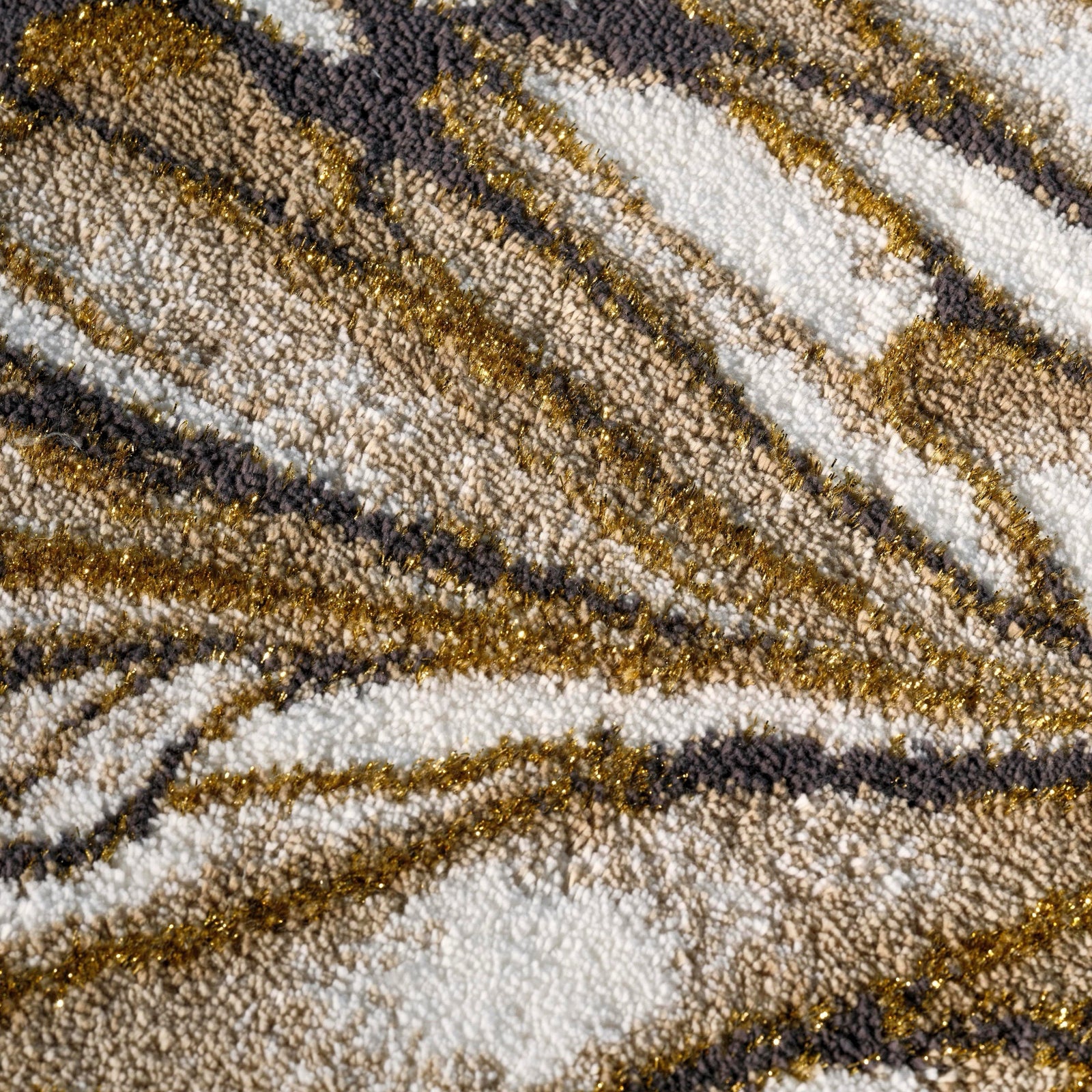 Gold Abyss Habidecor Diane Bath Rug beside stone bath tub