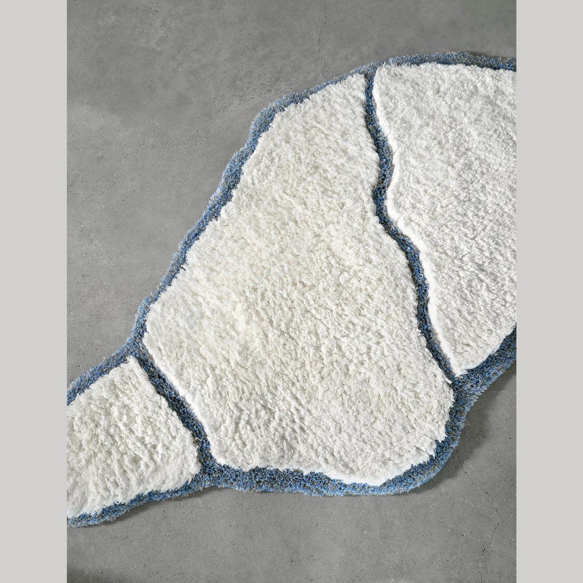 Abyss Habidecor Jess Bath Rug in Powder Blue (330) On Cement Floor