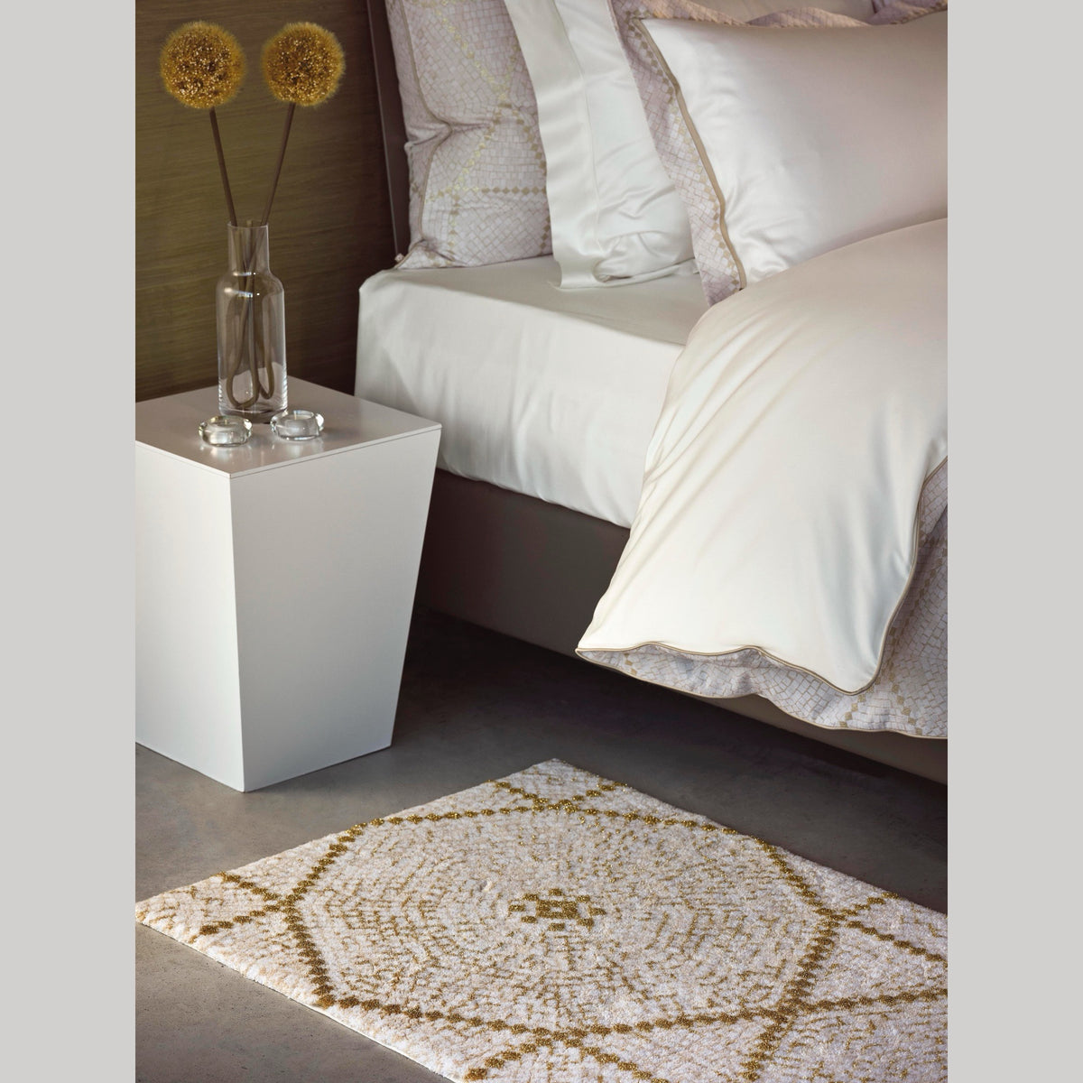 Closeup of Abyss Habidecor Kery Bath Rug in Gold (800) on Bedroom Floor