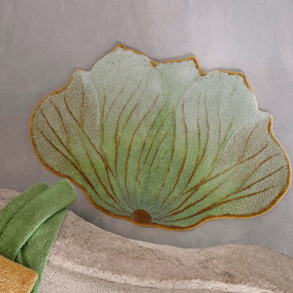 Aqua (210) Abyss Habidecor Lotus Bath Rug on cement floor