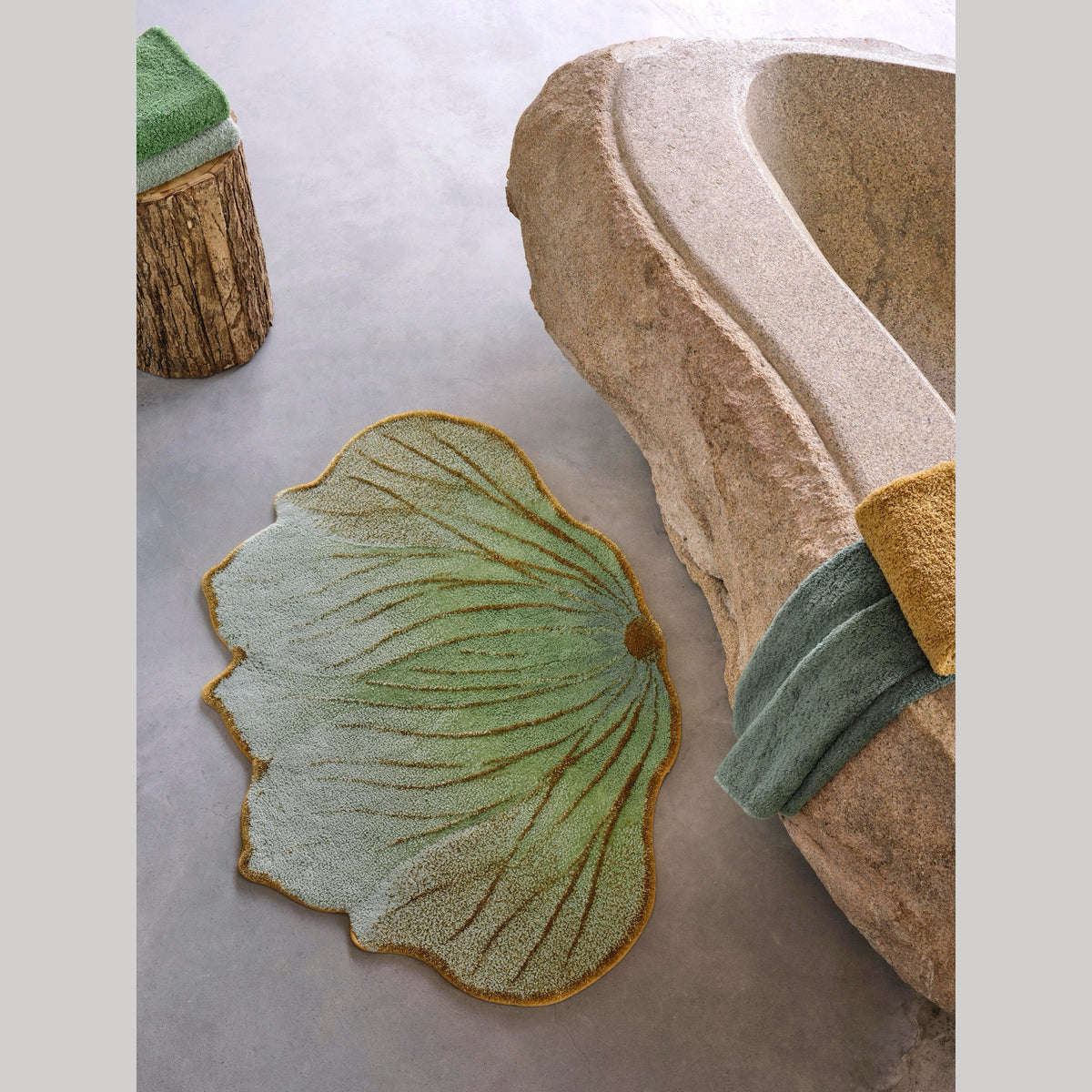 Aqua (210) Abyss Habidecor Lotus Bath Rug Beside a stone bath tub