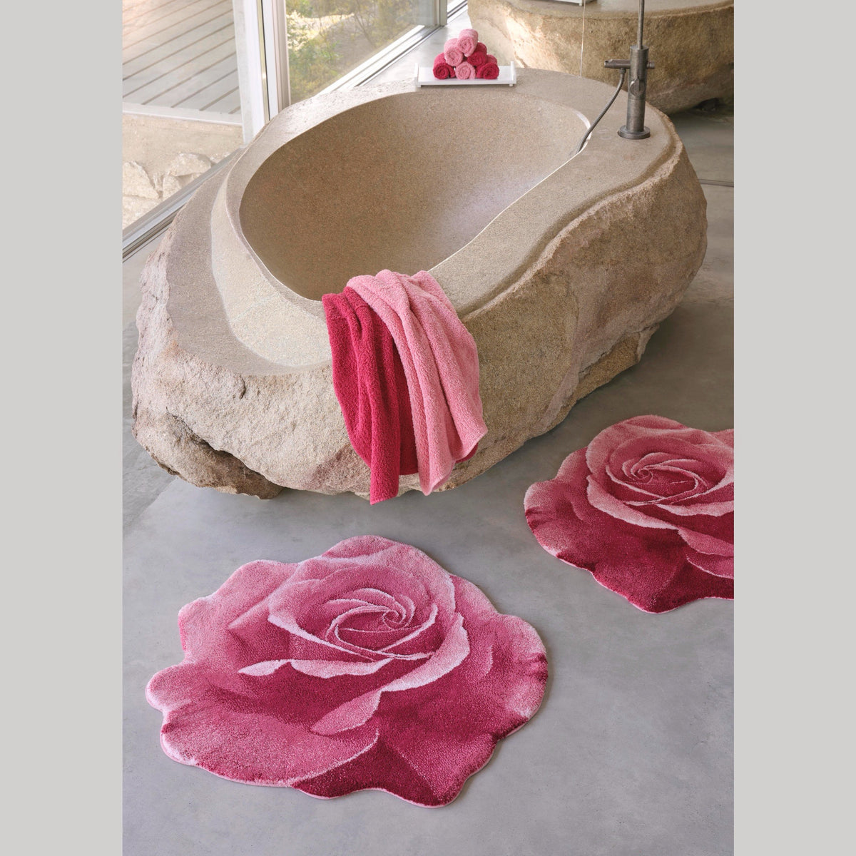 Flamingo (573) Abyss Habidecor Passion Bath Rugs beside a stone bath tub