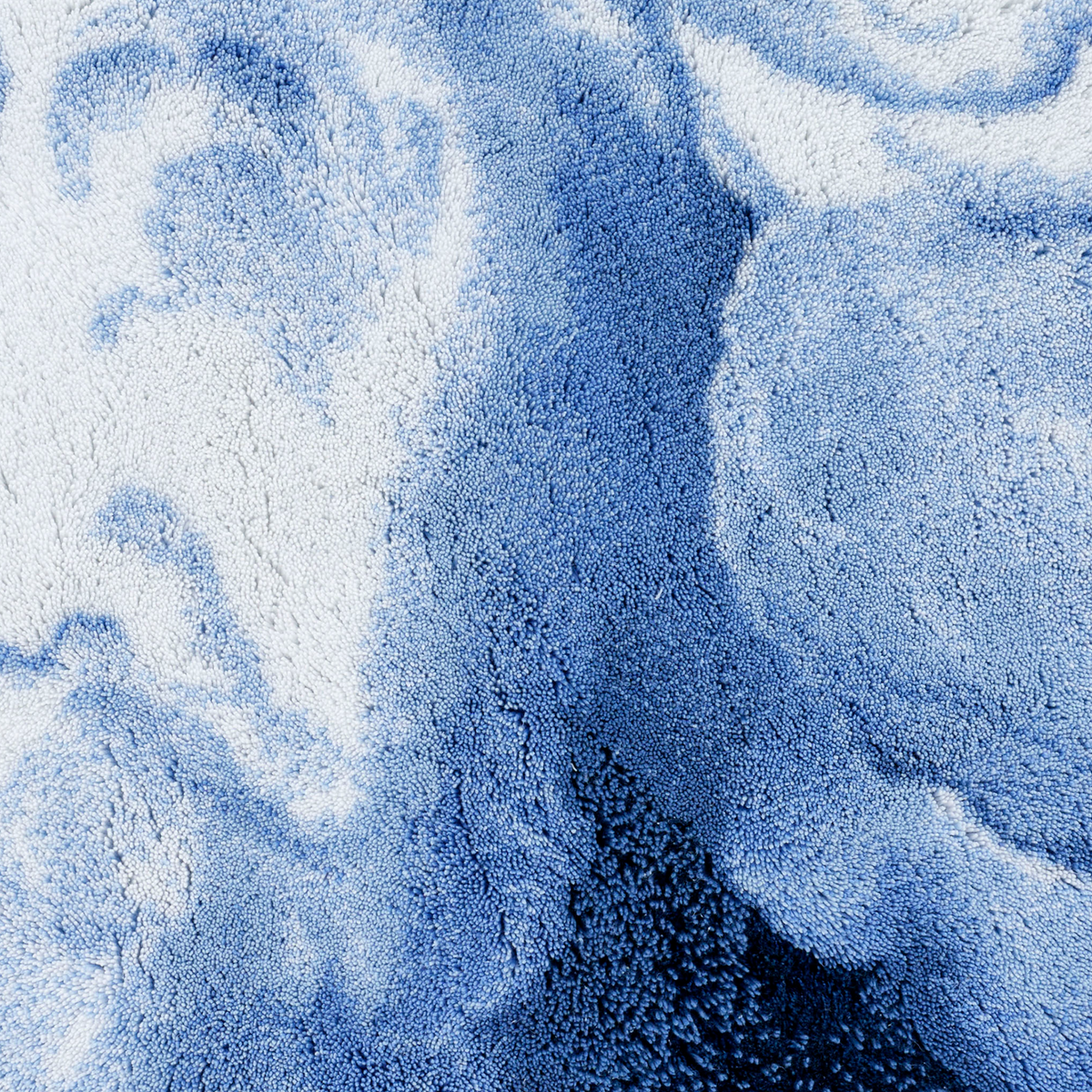 Close-up of a Regatta colored Abyss Habidecor Walker Bath Rug, featuring a cloud-like marbled pattern in plush Egyptian cotton