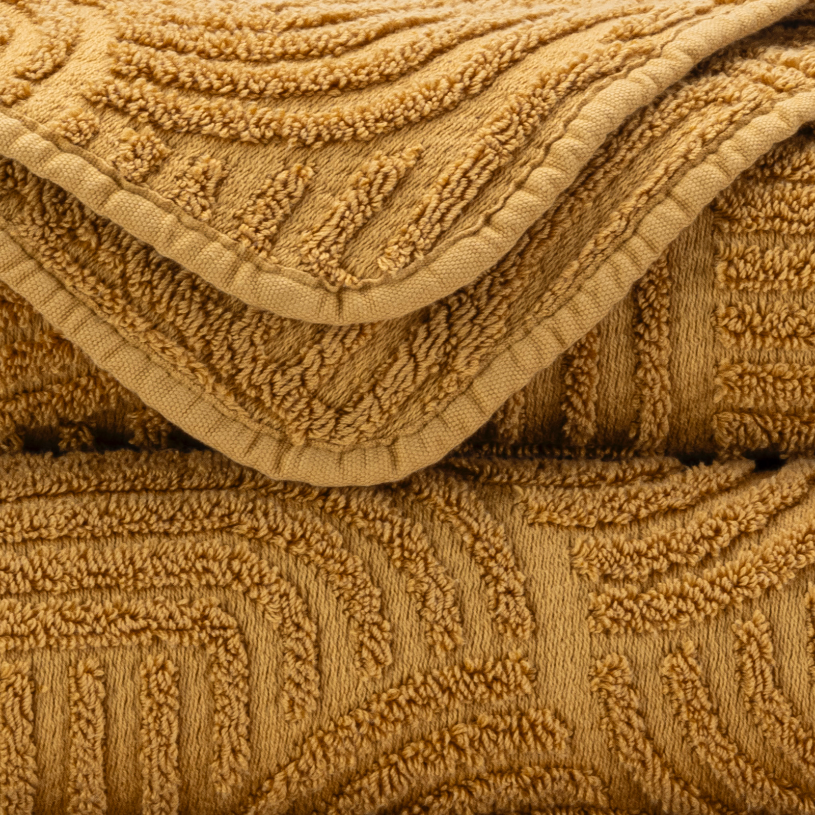 Corner Side Stack of Abyss Olly Bath Towels in Gold Color