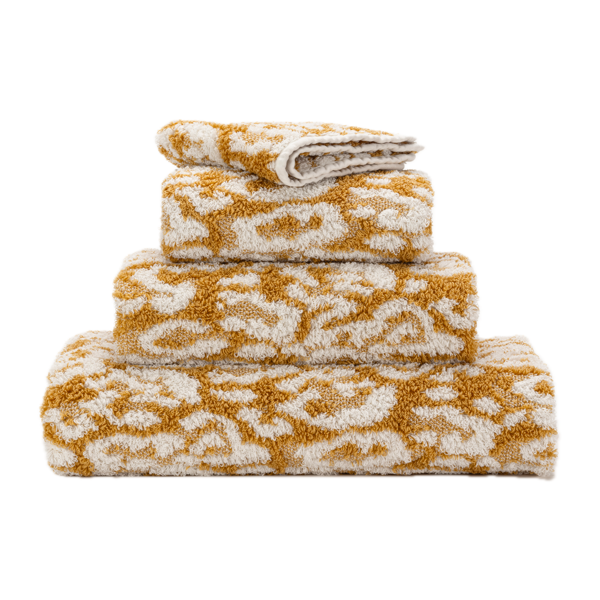 Stack of Abyss Sauvage Bath Towels in Gold Color