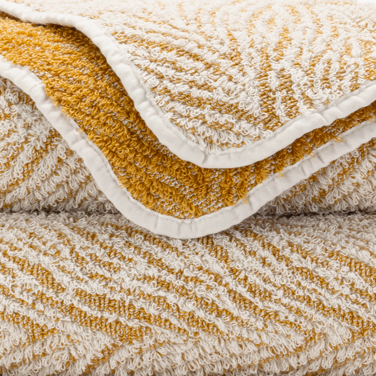 Closeup of Abyss Vasco Bath Towels on Gold Color