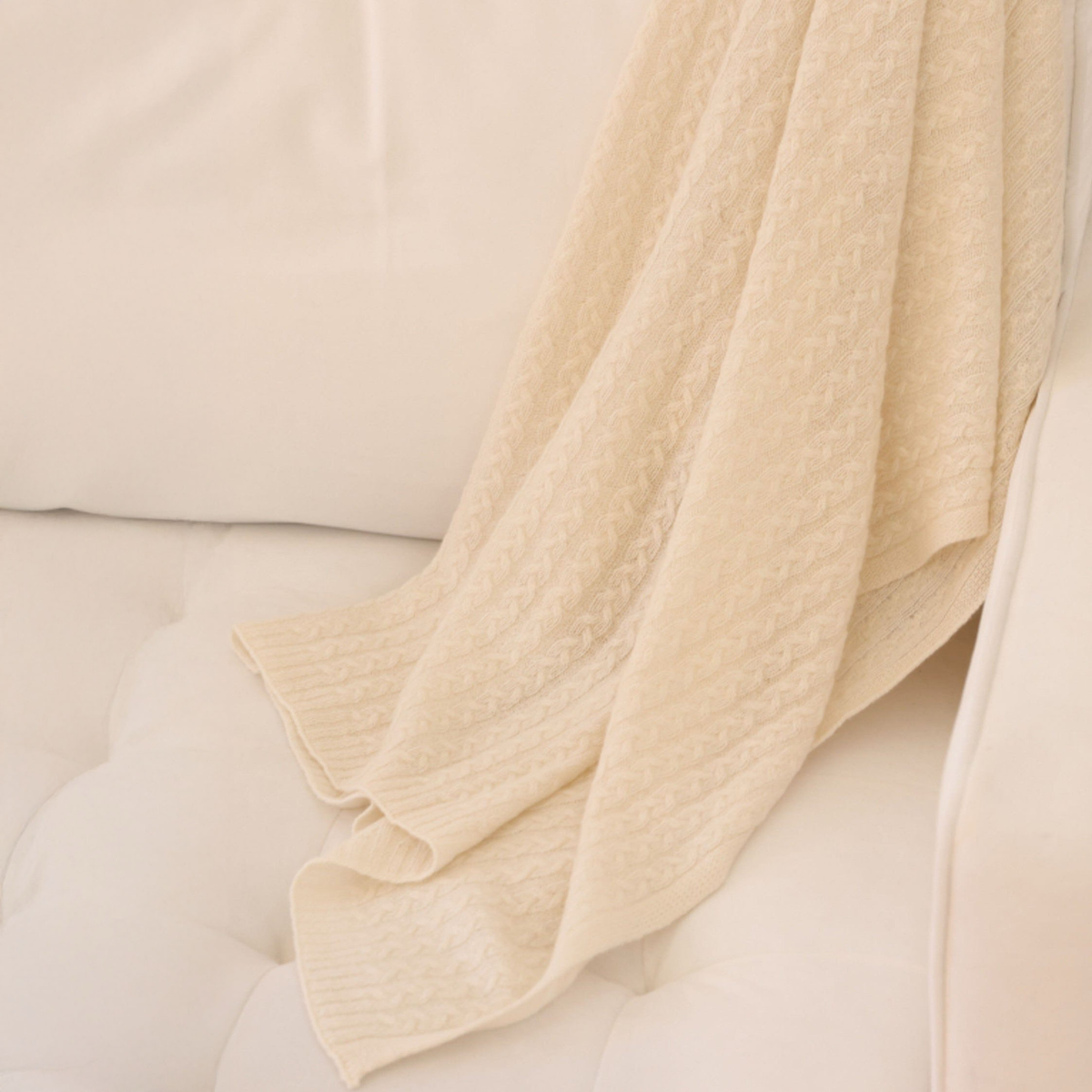 Snow Alashan Bailey Braided Cable Knit Baby Blanket on a couch