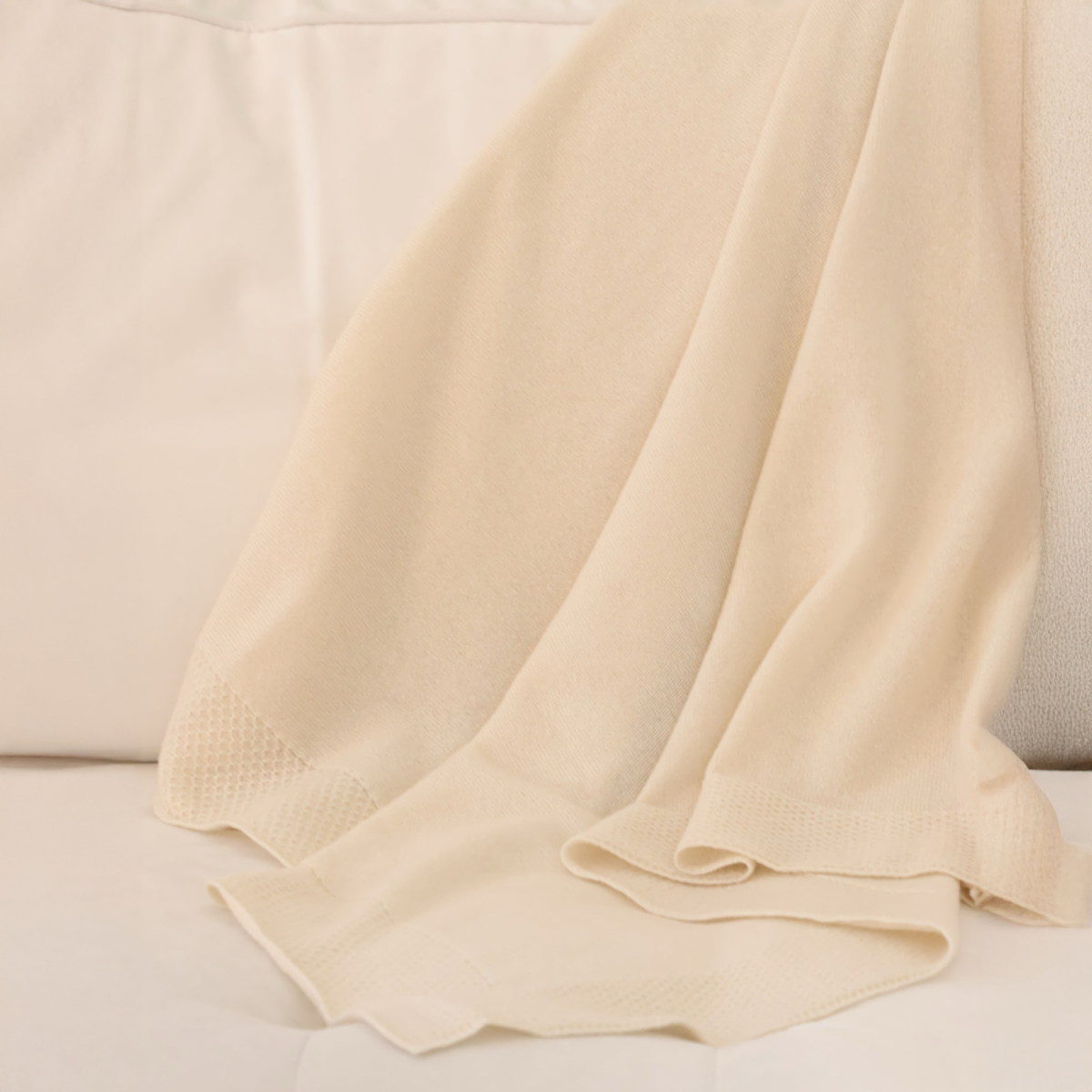 Draped Alashan Hayden Honeycomb Edge Knit Baby Blanket in Snow