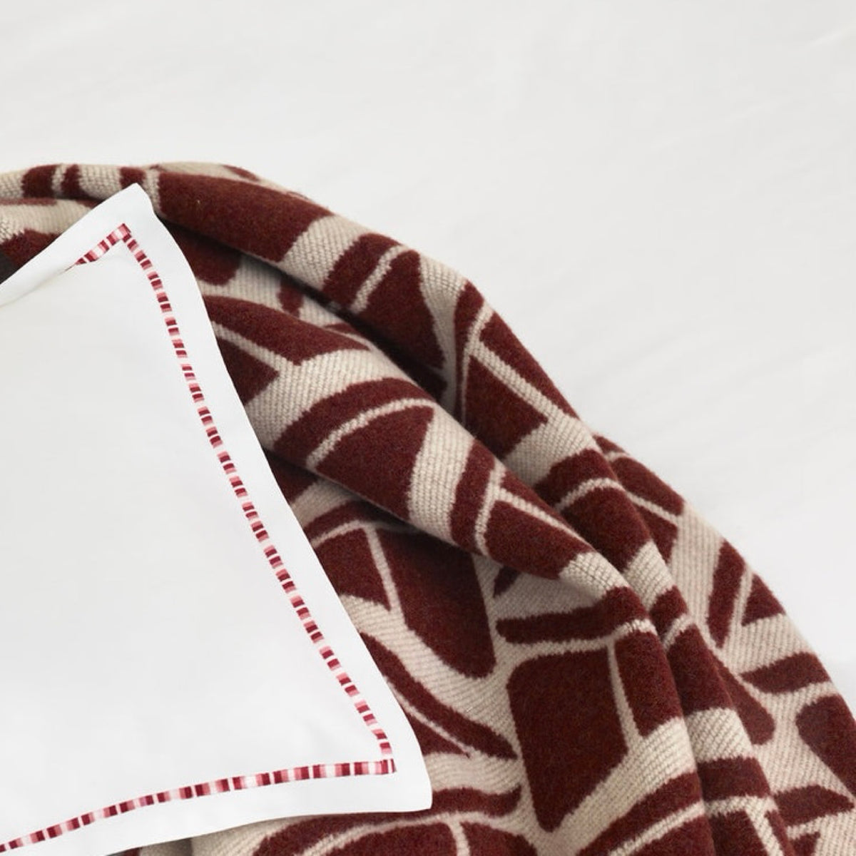 Burgundy Amalia Ama Throw with a white pillow with red piping