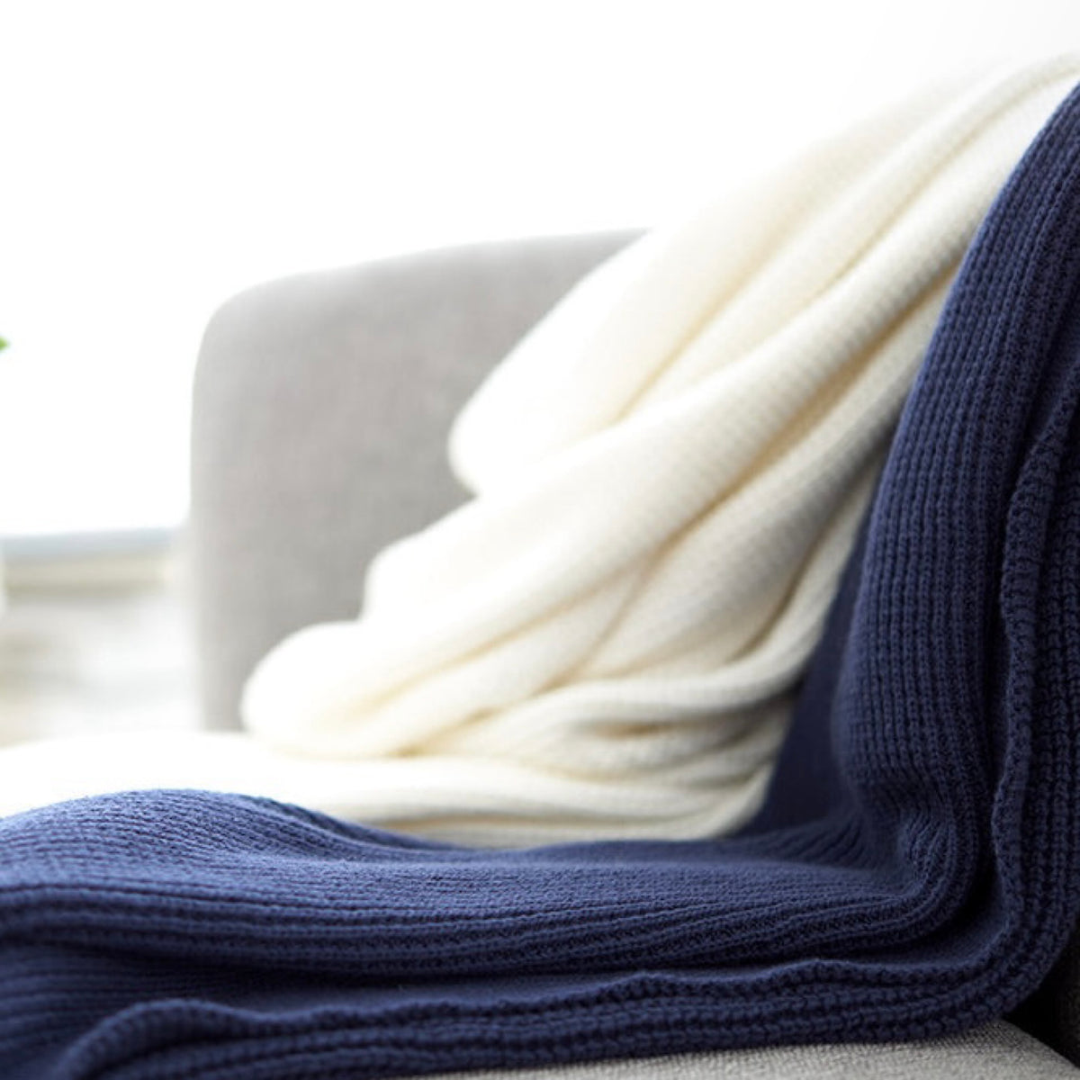 Closeup of Amalia Elemento Throws in Cream and Midnight colors