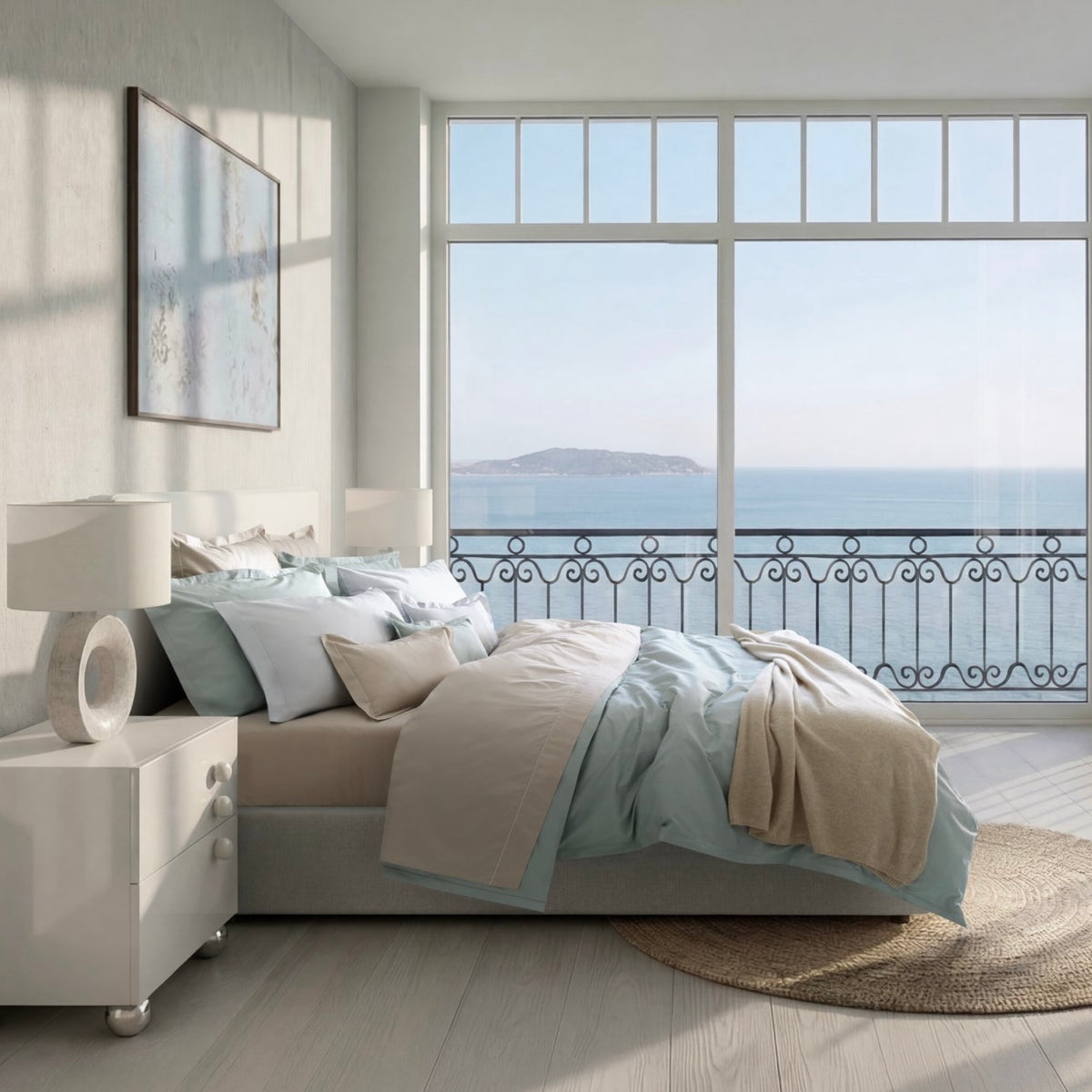 A made bed with luxury Mist Blue Amalia Fresco Giza 94 Bedding faces a large window overlooking the ocean