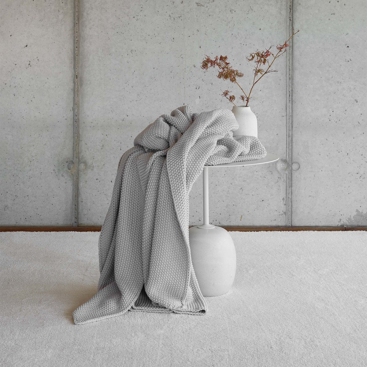 Amalia Lilium Throws in Cool Grey color draped on a table
