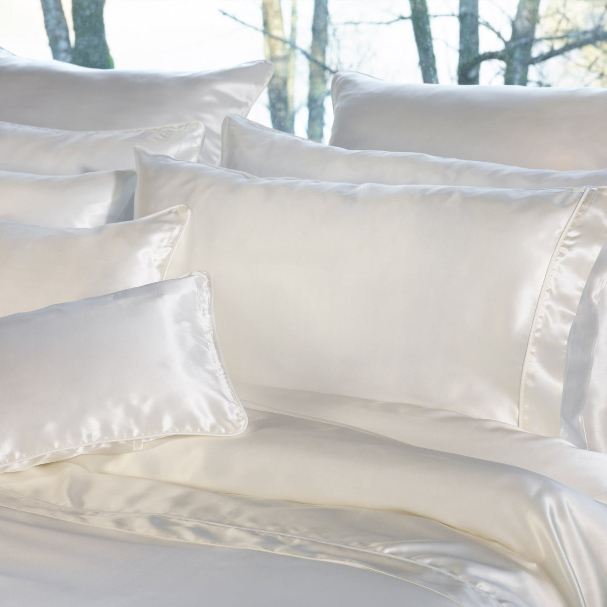 A bed with multiple Natural Amalia Maria Mulberry Silk Shams and Pillows