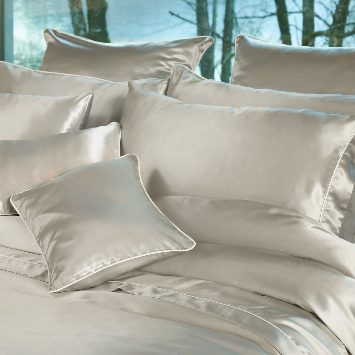 A bed with multiple Silver Amalia Maria Mulberry Silk Shams and Pillows