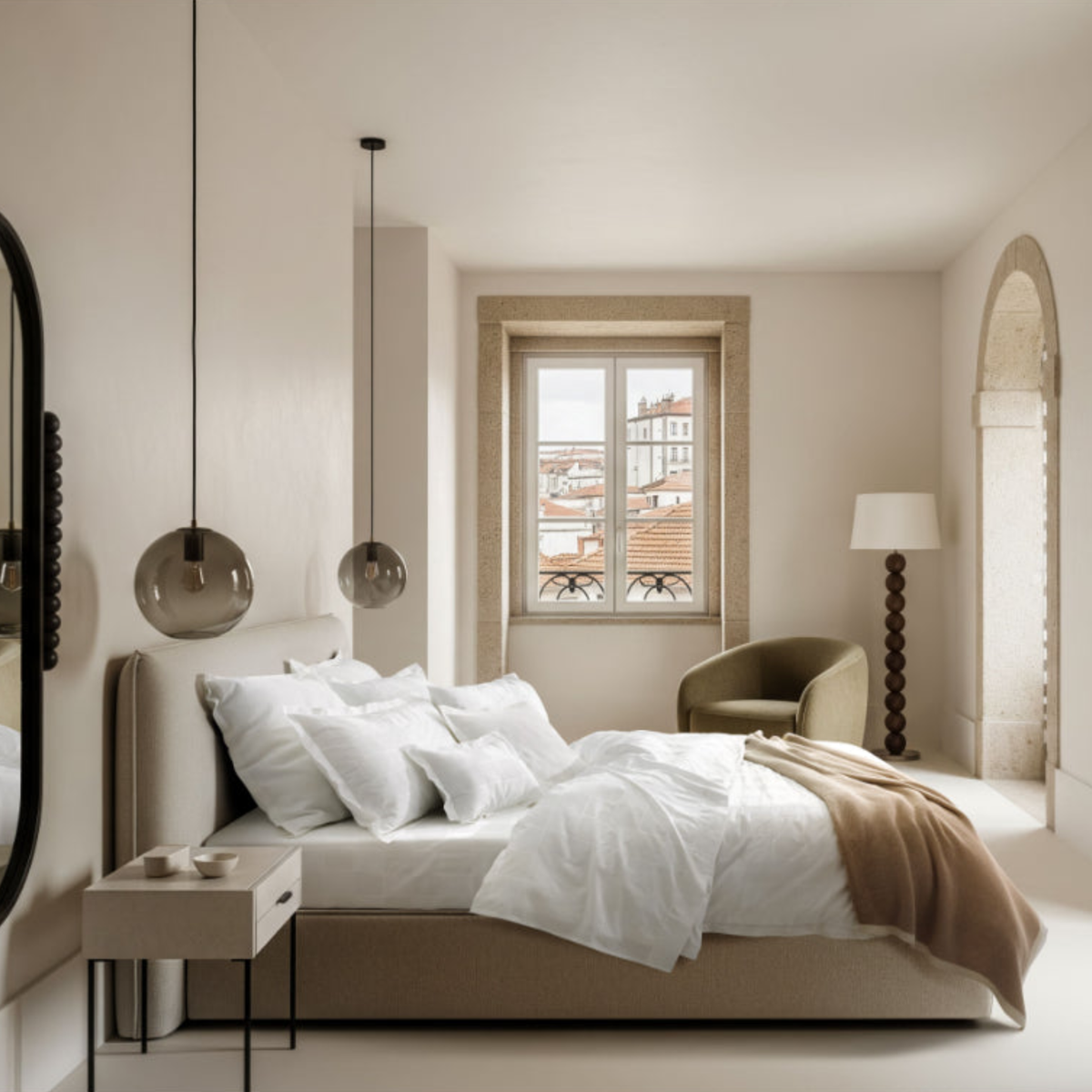 A modern bedroom with a platform bed featuring Amalia Sagres Giza 92 Jacquard Bedding, pendant lights, a side table, and an armchair.