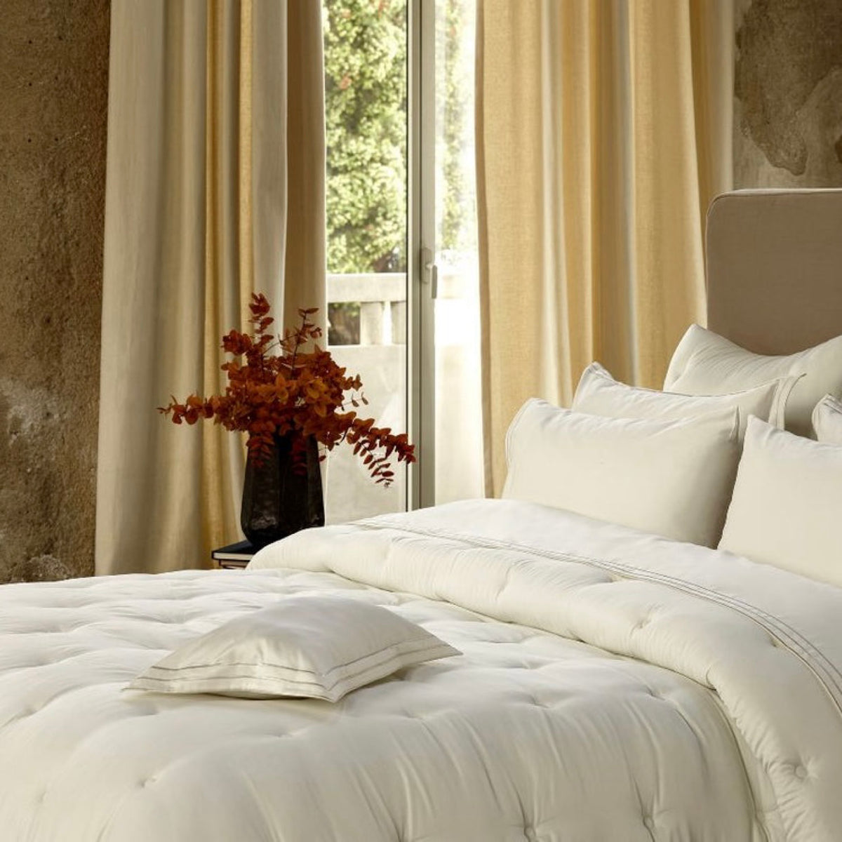 Bed with Swatch of Cream Amalia Savia Quilted Coverlet beside a window