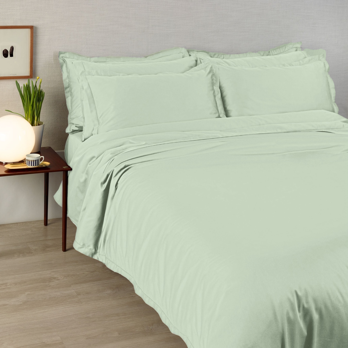 A bed made with 430 thread count Verbana Amalia Suave Giza 94 Bedding, next to a brown leather nightstand with a lamp