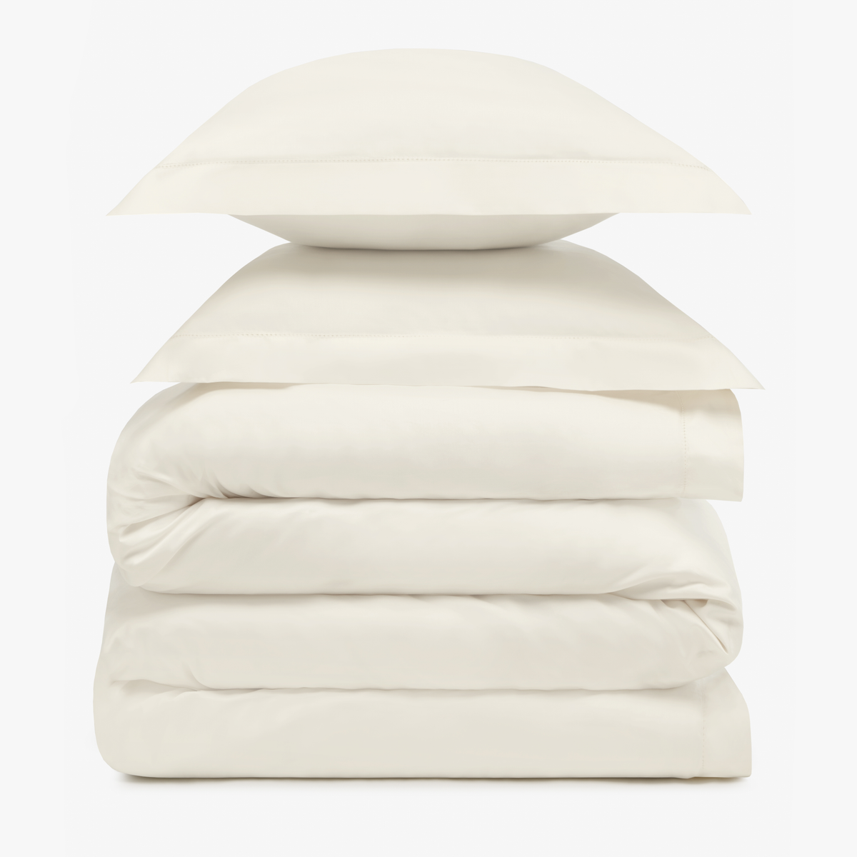 A stack of two cream pillows resting on folded Amalia Duvet Bedding Sheets