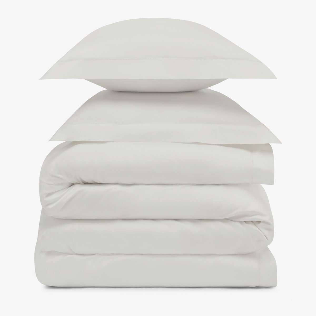 A stack of two Pale Grey pillows resting on folded Amalia Duvet Bedding Sheets
