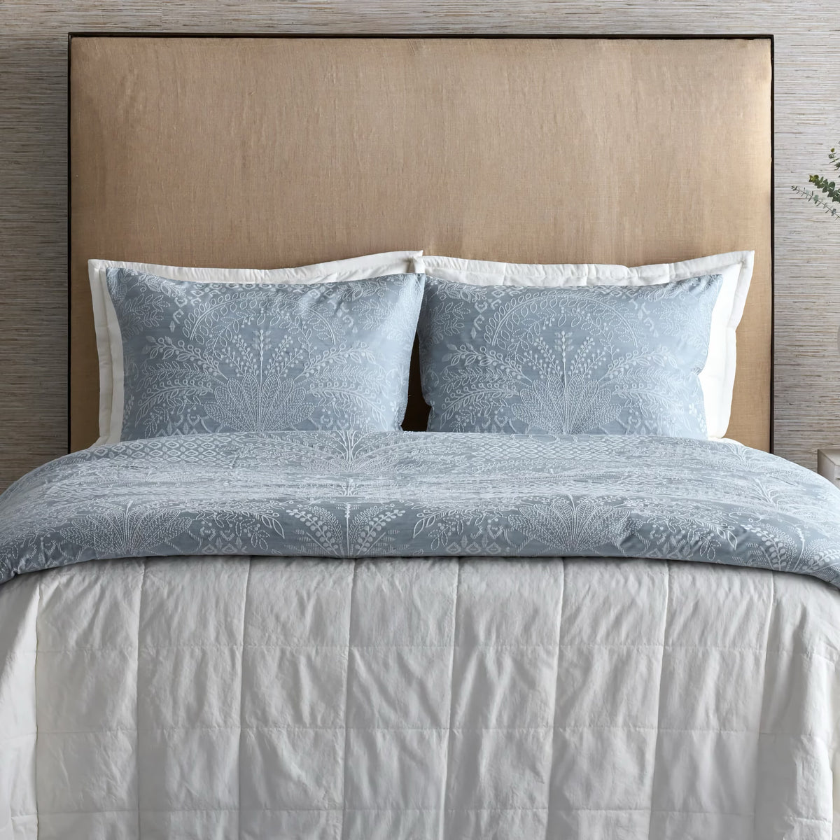Front view of bed with Bone colored Ann Gish Cotton Canvas Coverlet Set and blue bedding as coordinates