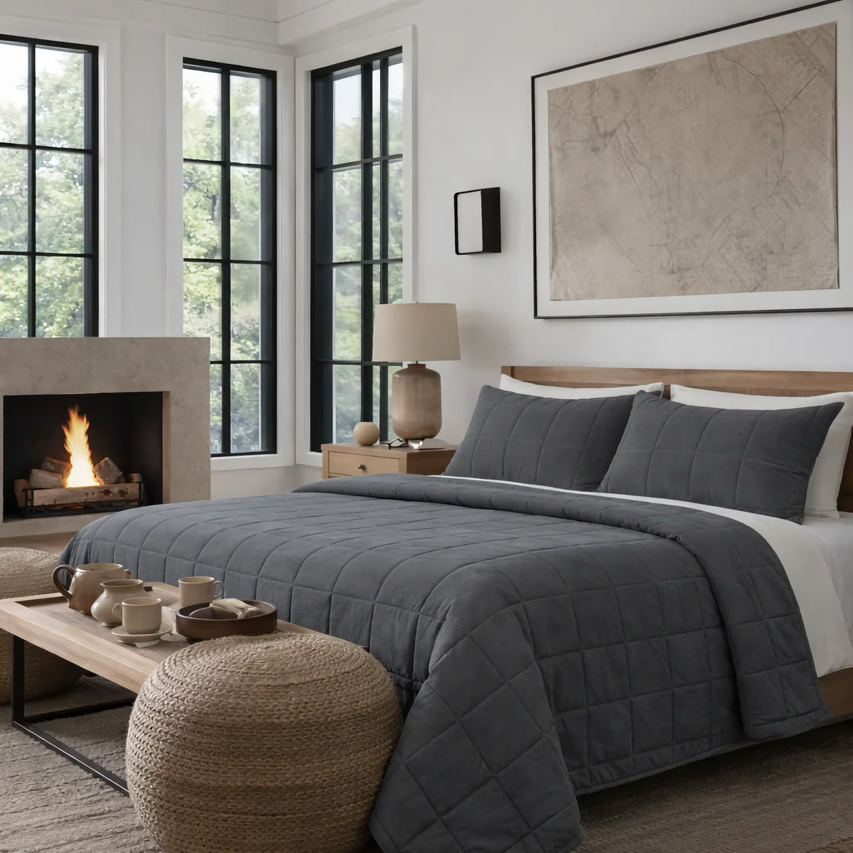 A neatly made bed with Charcoal colored Ann Gish Cotton Canvas Coverlet Set in a bright room with big windows