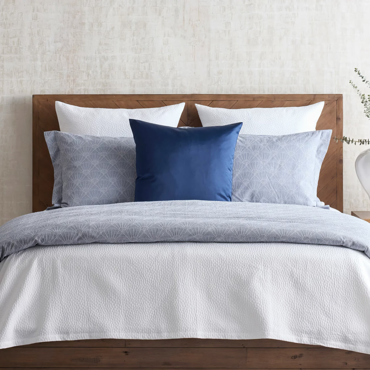 Indigo-colored Ann Gish Crest Duvet Set with blue pillow