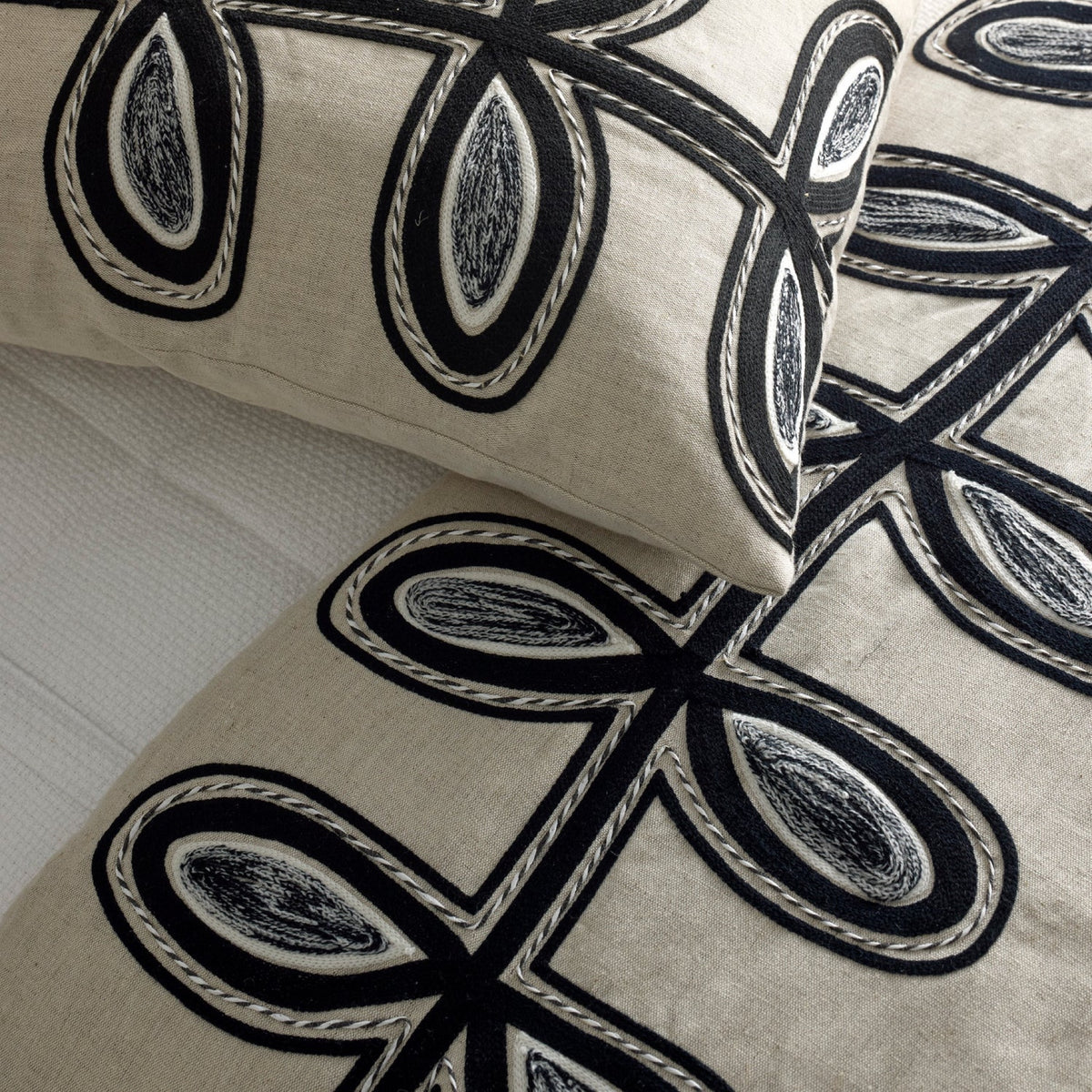 Close-up of Ann Gish Fellini Throw and Decorative Pillows in Natural and Charcoal colors