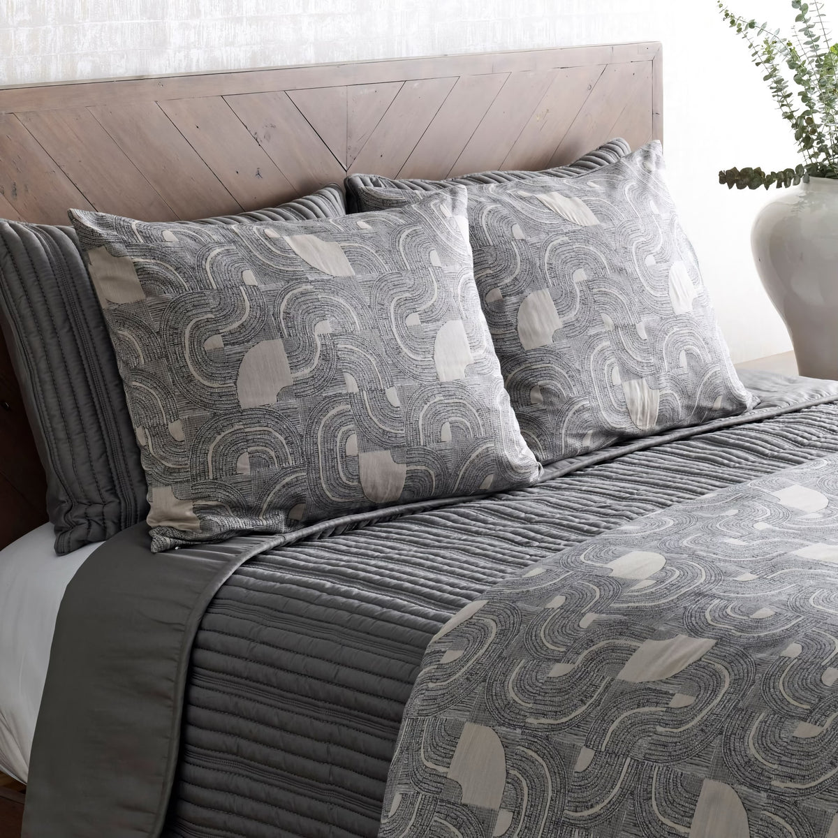 Side view of Charcoal and Pumice-colored Ann Gish Lugano Comforter Set with coordinate grey bedding 