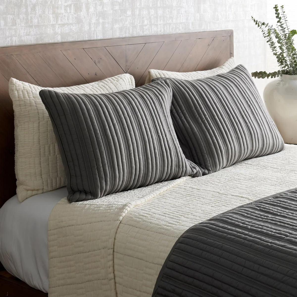 Side view of Bone colored Ann Gish Pickstitch Coverlet Set with charcoal bedding coordinate