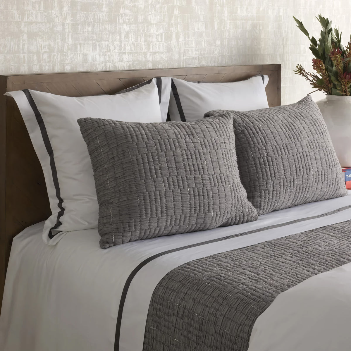 Side view of Charcoal colored Ann Gish Pickstitch Coverlet Set with grey lining bedding coordinate