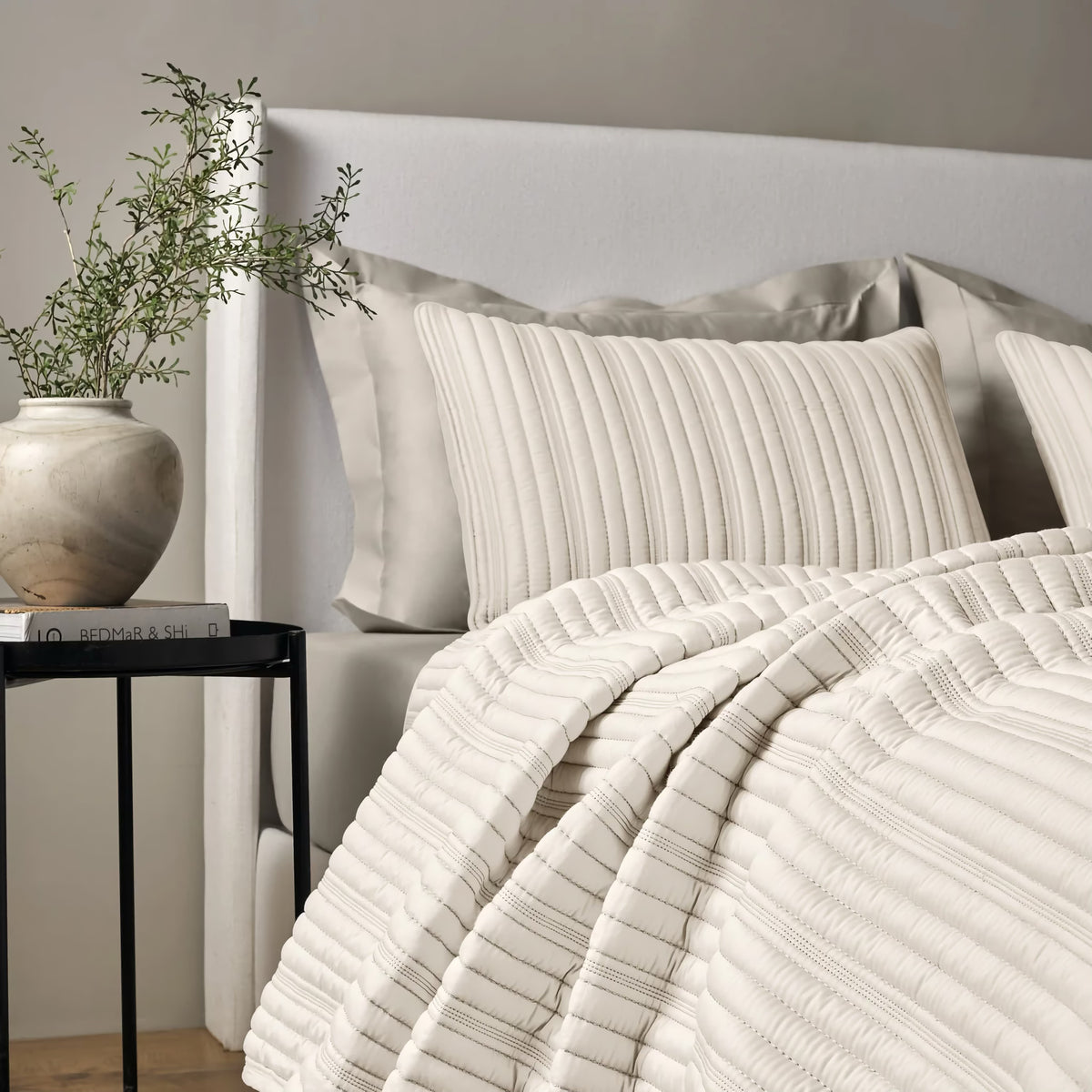 Side view of a bed with Bone colored Ann Gish Rib Coverlet Set