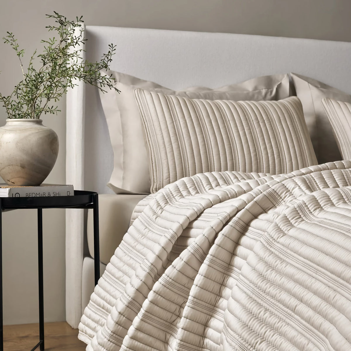 Side view of a bed with Pumice colored Ann Gish Rib Coverlet Set