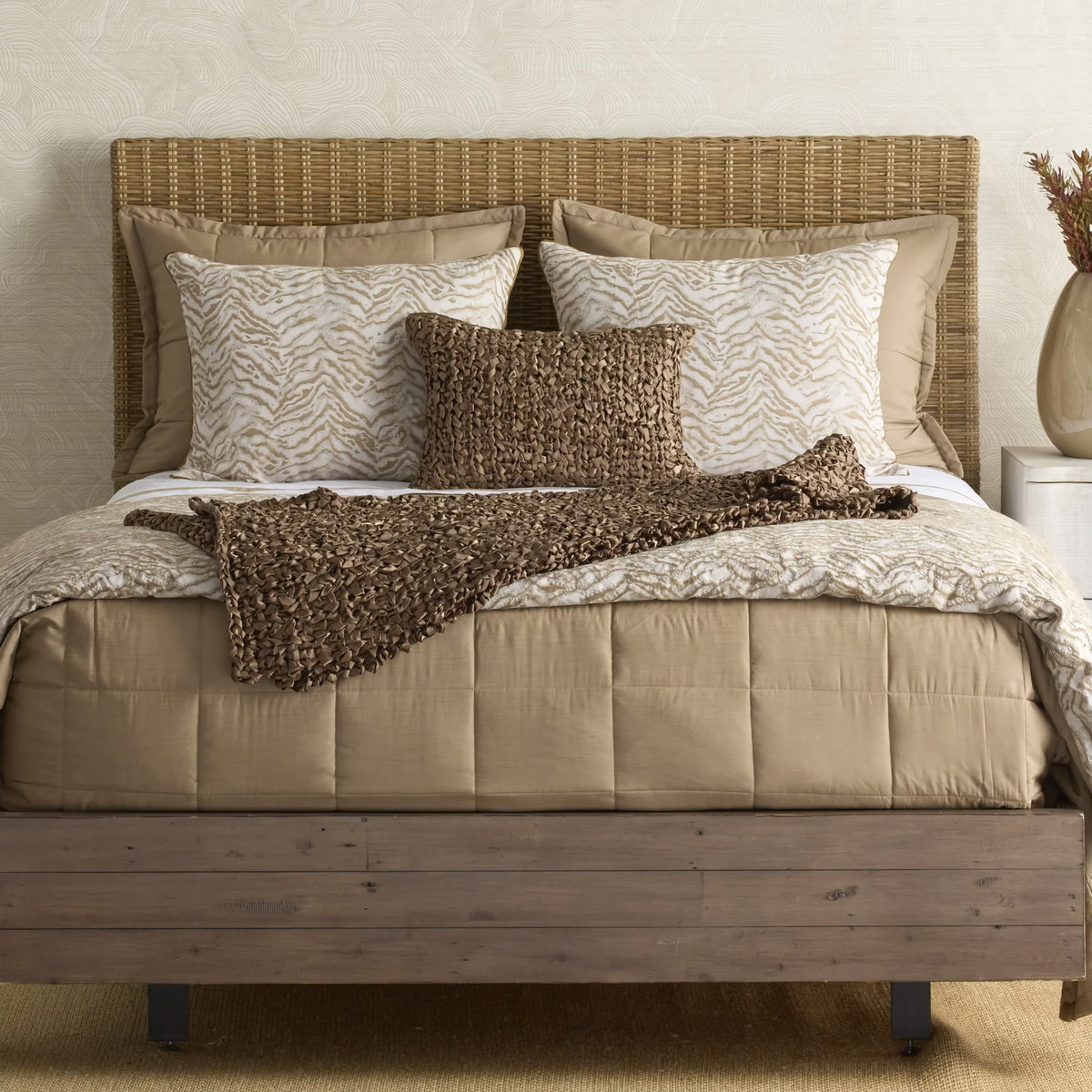 Cafe au Lait colored Ann Gish Slub Tencel Quilted Coverlet Set with tan bedding, patterned pillows, a quilted bedspread, and a wicker headboard