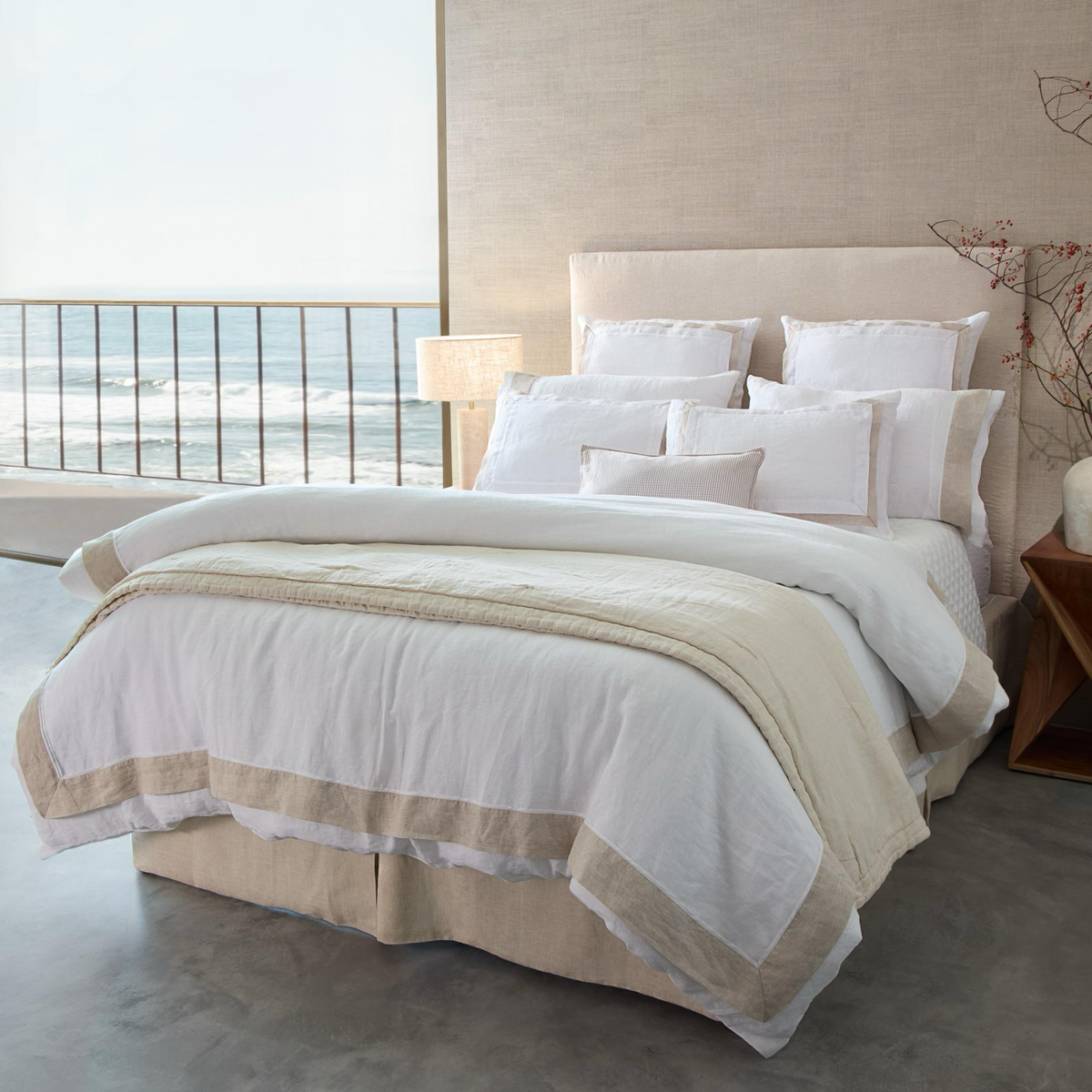 BOVI Marbella Bedding in White and Flax colors with the sea in the background
