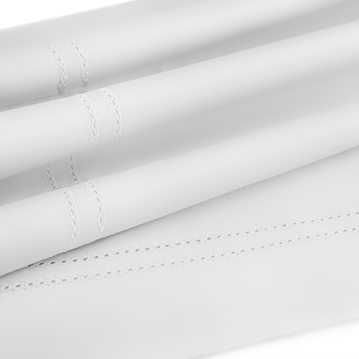 Close-up of neatly folded BOVI Simply Sateen Bedding with decorative stitched detailing near the edges.