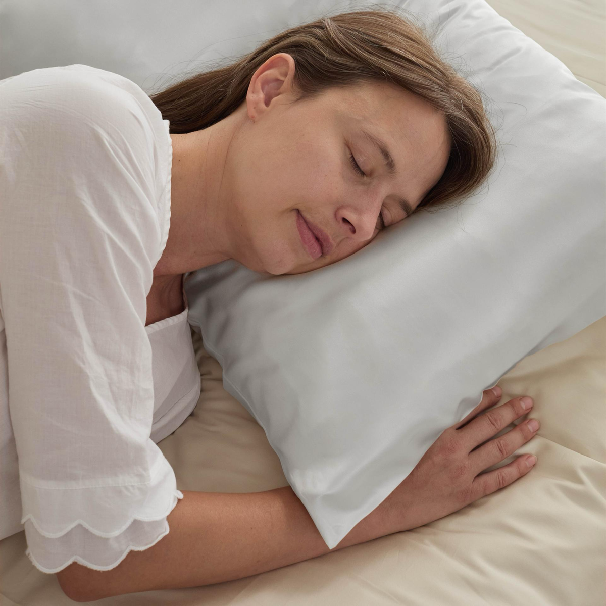 A woman is soundly sleeping on a BOVI Simply Silk Pillowcase. 