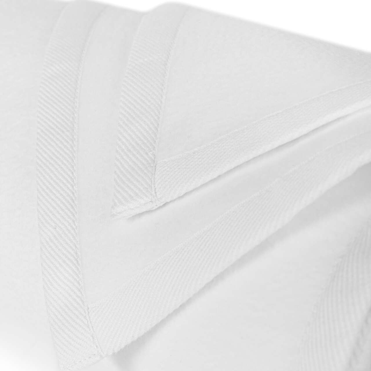 White BOVI Finnley blanket draped over a beige chair on a carpeted floor